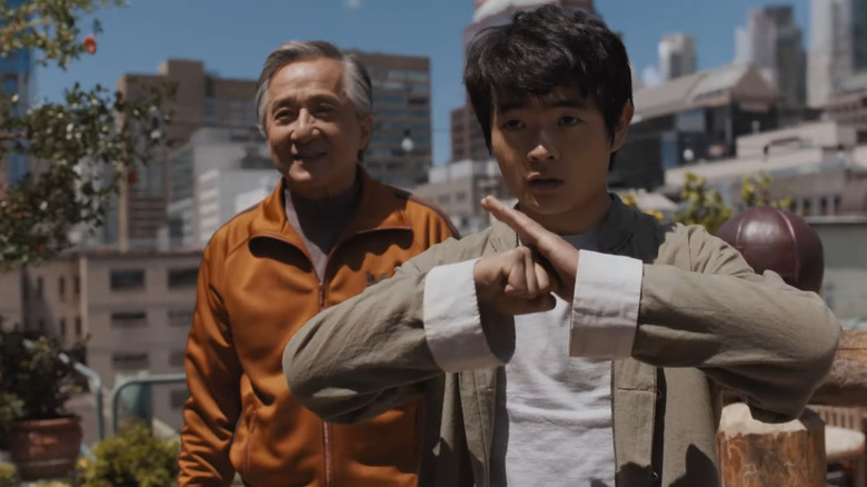Li does the kung fu greeting next to Mr. Han in Karate Kid: Legends