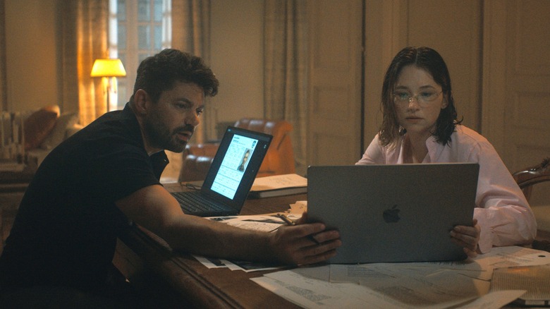 Dominic Cooper as Havlock and Haley Bennett as CIA agent Sidney Scofield seated at a desk looking at a laptop screen in The Last Frontier