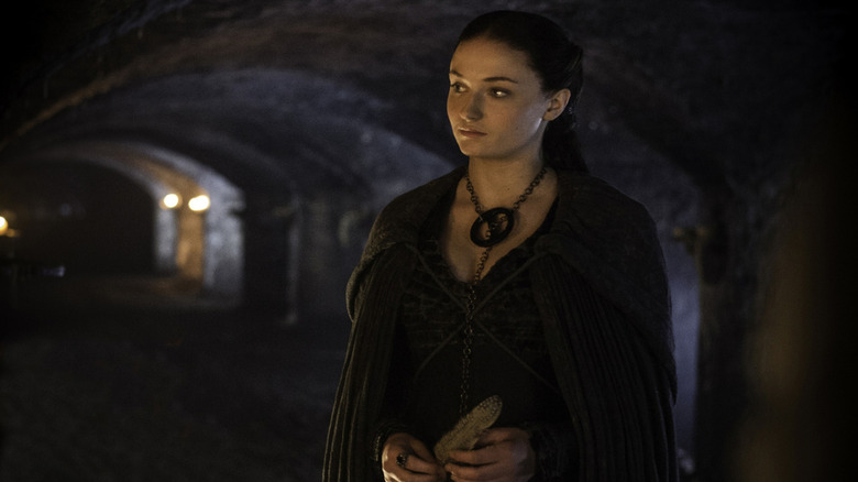 Sansa in dark clothing with dark hair in the crypts on Game of Thrones