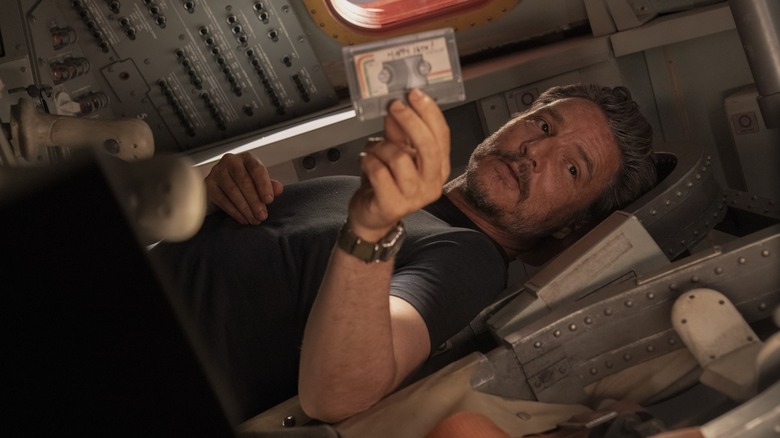 Joel holding a cassette tape laying horizontally in The Last of Us