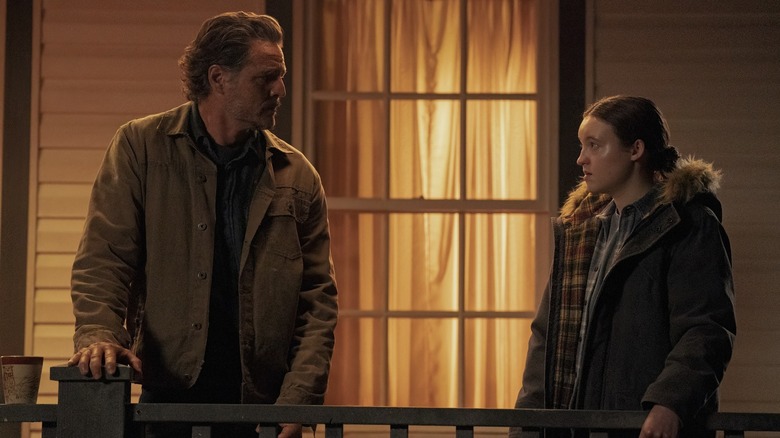 Joel and Ellie looking at each other on the porch in The Last of Us