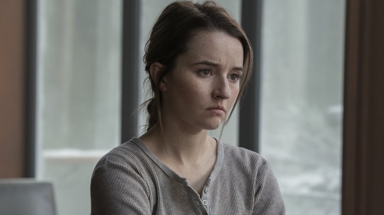 Abby in a gray henley looking sad near a window in The Last of Us