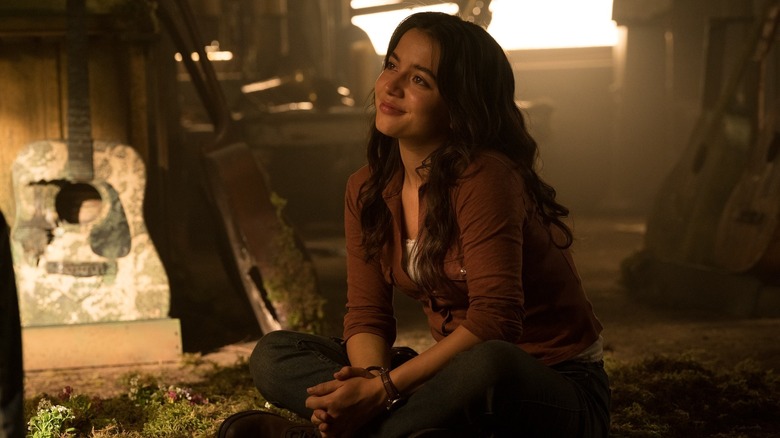 Dina sitting and looking up lovingly at Ellie off-screen in The Last of Us season 2