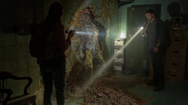 Bella Ramsey's Ellie and Pedro Pascal's Joel examining a Cordyceps infected on The Last of Us