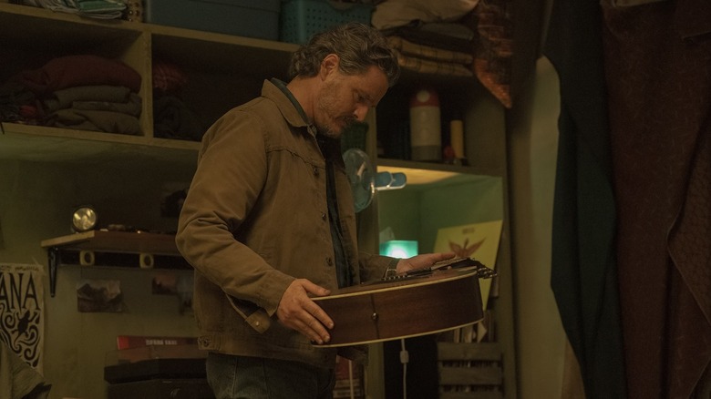 Pedro Pascal's Joel Miller holding a guitar on The Last of Us