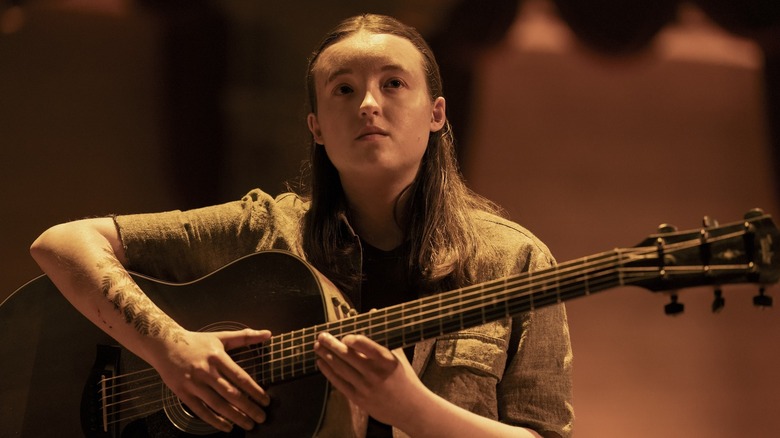 Bella Ramzi at Elie sat with a guitar on stage at the end