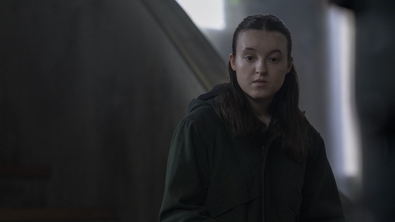 Ellie standing up and looking down in a dark building in the last season 2