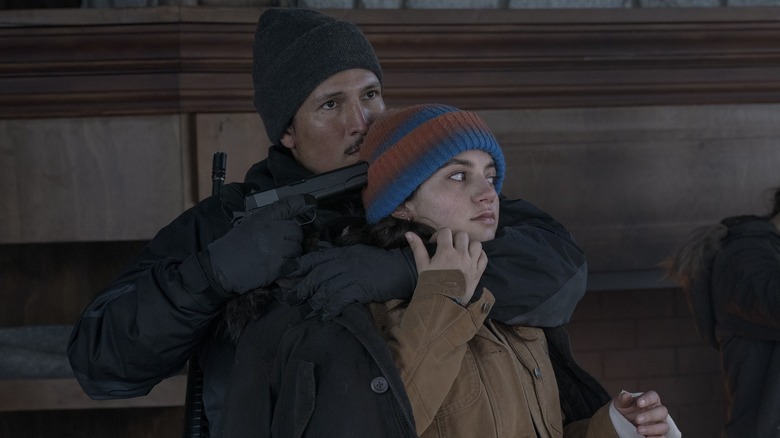 Manny holding a gun to Dina's head on The Last of Us