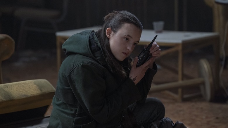 Ellie listening to a walkie-talkie in The Last of Us