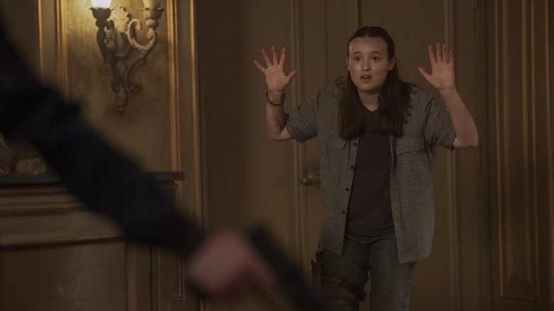 Ellie with her hands up in surrender on The Last of Us