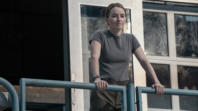 Kaitlyn Dever as Abby leaning on a railing on a sunny day in The Last of Us