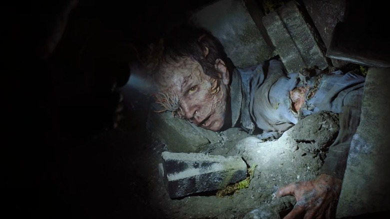 An infected crawls from the ground in The Last of Us