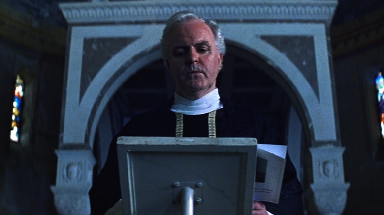 James Handy as a priest memorializes the victims of a train wreck in Unbreakable