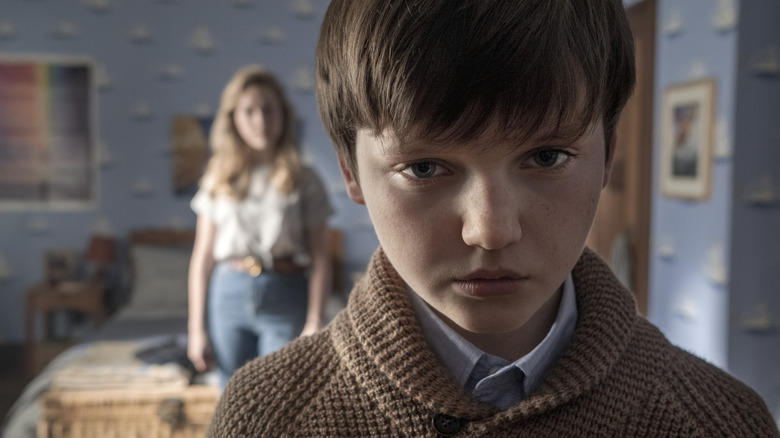 Miles has an evil look in his eye while Dani watches him in The Haunting of Bly Manor