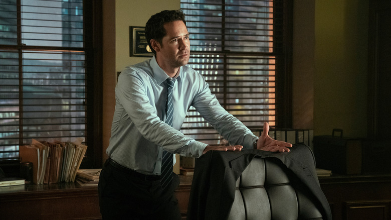 Mickey Haller stands behind his chair contemplating his next move in 