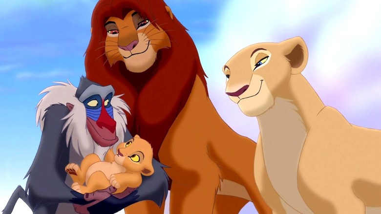 Rafiki holds Kiara while Simba and Nala stand next to him in The Lion King II: Simba's Pride