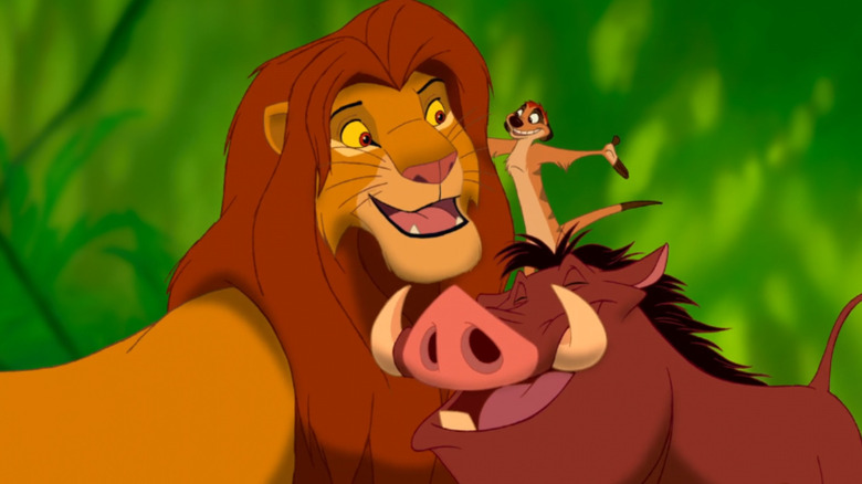 Simba stands next to Timon and Pumbaa in The Lion King