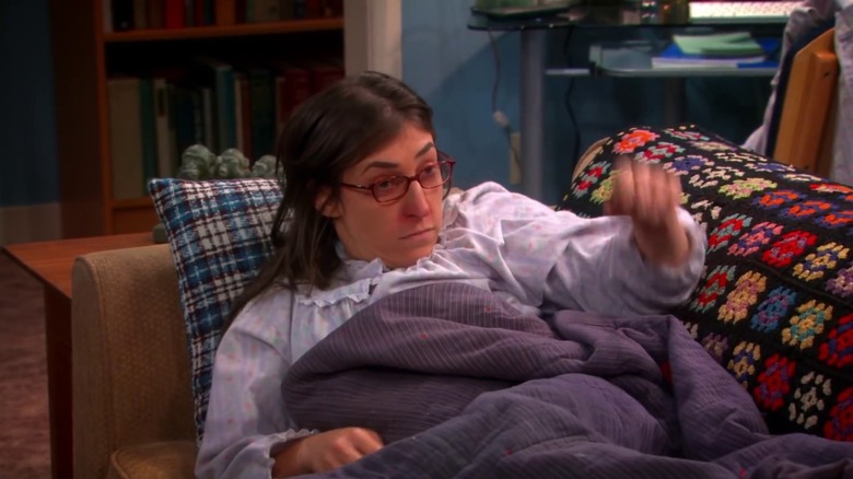 Amy is sick on the couch on The Big Bang Theory