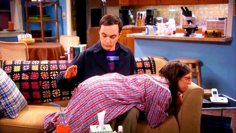 Sheldon hits Penny on the couch in The Big Bang Theory