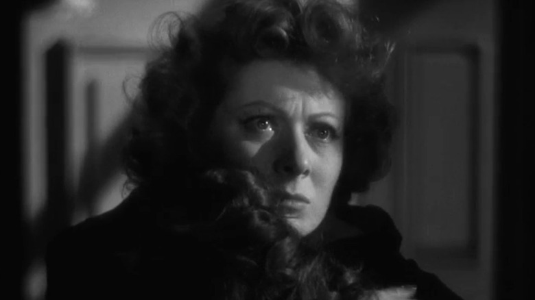 Greer Garson as a Kay Miniver looks away while holding someone, tears in his eyes, in Mrs. Miniver