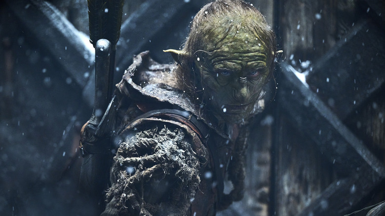 Adam Young as Marnûkh wearing armor and a quiver of arrows while standing in the snow in The Lord of the Rings: The Rings of Power
