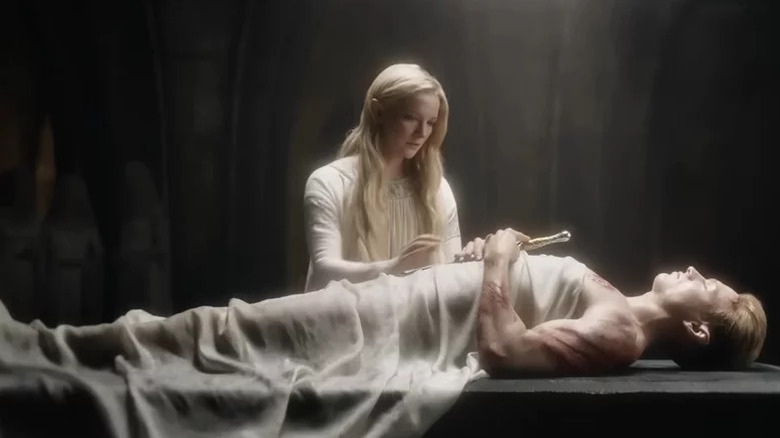 Galadriel (Morfydd Clark) moves to touch the body of Finrod (Will Fletcher) as he lies clutching a sword in The Lord of the Rings: The Rings of Power