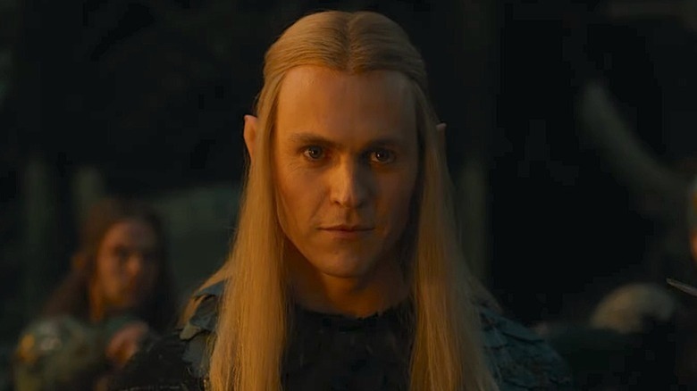 Annatar (Charlie Vickers) stands surrounded by suspicious elves in The Lord of the Rings: The Rings of Power