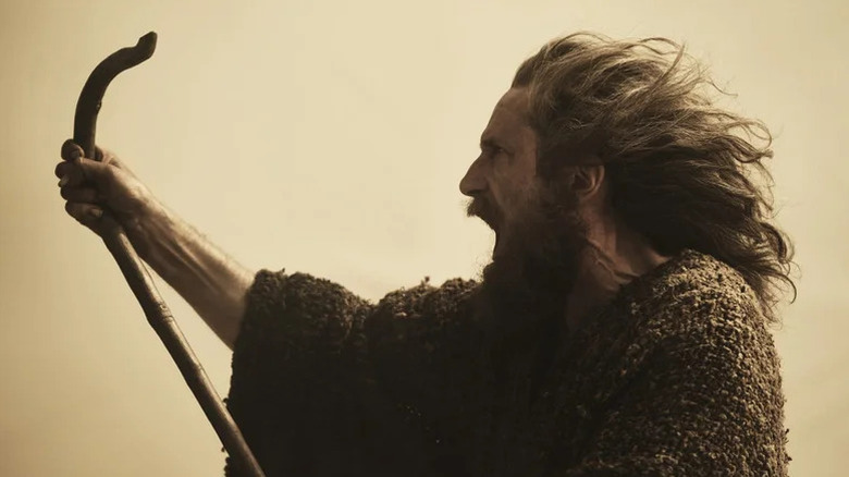 Gandalf (Daniel Weyman) shouts while holding up a staff in The Lord of the Rings: The Rings of Power