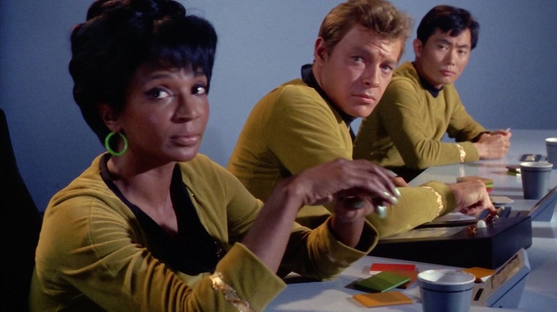 Uhura, Bailey, and Sulu sitting at a table on Star Trek