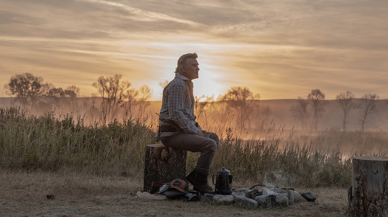Preston Clyburn de Kurt Russell est assis sur une souche d'arbre au coucher du soleil dans le Madison