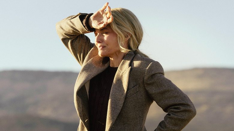 Michelle Pfeiffer's Stacy Clyburn holds her hand to her forehead as she stands in a field in The Madison
