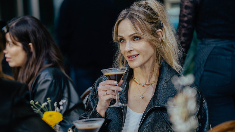 Beau Garrett's Abigail Reese holds an espresso martini as she sits outside at a restaurant in The Madison