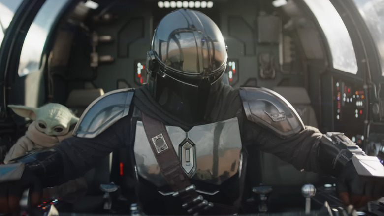 Din Djarin taking off in the Razor Crest with Grogu behind him in The Mandalorian and Grogu