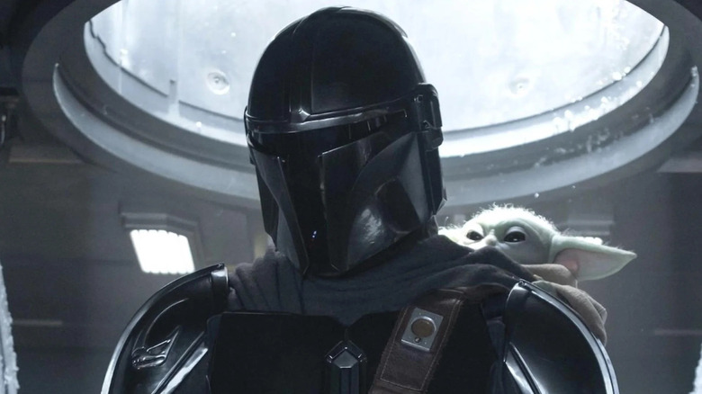 The Mandalorian and Grogu stand in an AT-AT cockpit