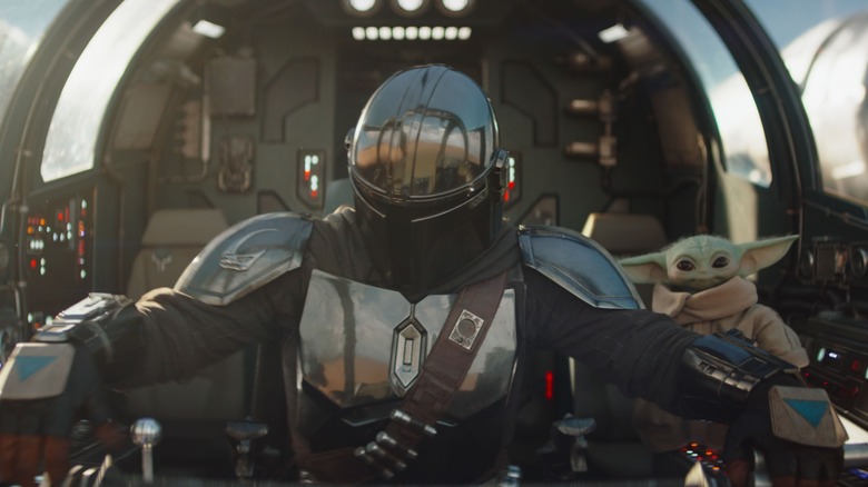 Grogu looks amused as Din flies his craft in The Mandalorian and Grogu