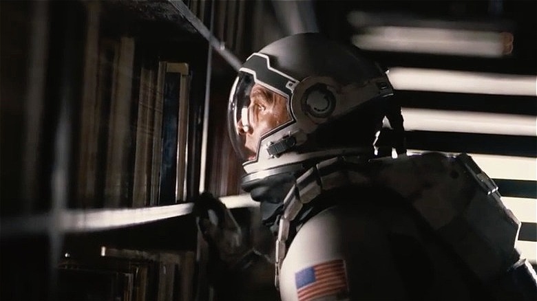 Interstellar Cooper looking through bookshelf