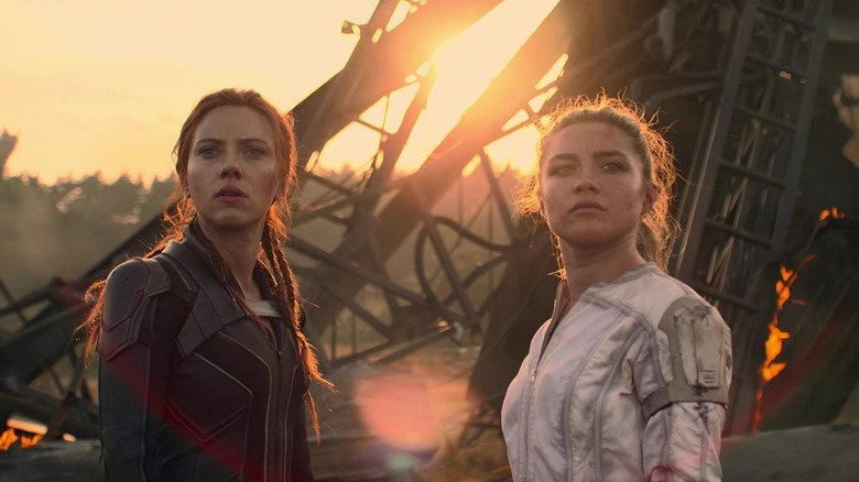 Black widow Willina stands between a shattering structure in the black widow