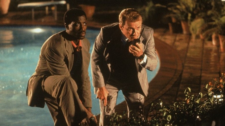 Web Smith and Tom Graham crouching by a pool in Rising Sun