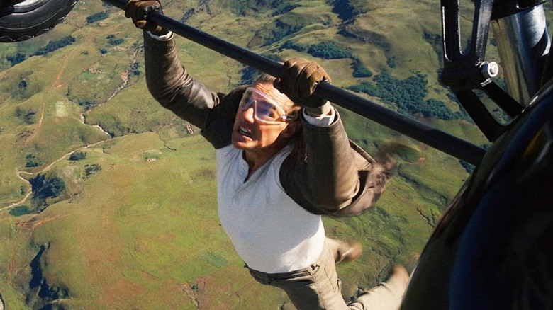 Tom Cruise as Ethan Hunt hanging from a plane in Mission: Impossible – The Final Reckoning