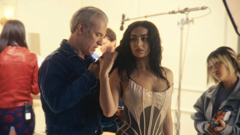 Charli XCX is attended to by her costumer in The Moment