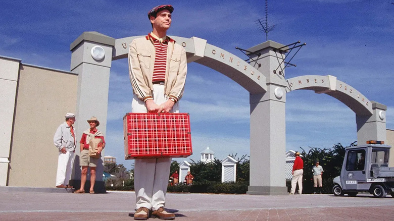 Jim Carrey holding a suitcase in The Truman Show