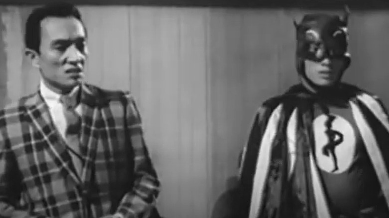 James Batman standing next to man in suit