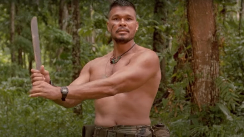 Shirtless man brandishing machete