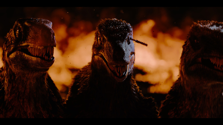 Three raptors standing in front of flames in Primitive War