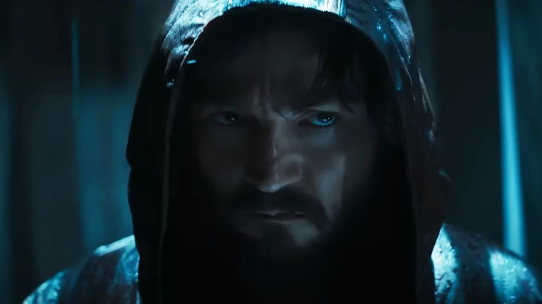 Cassian grimaces in hood