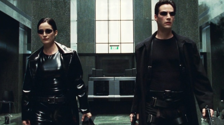 Trinity and Neo in trench coats in The Matrix