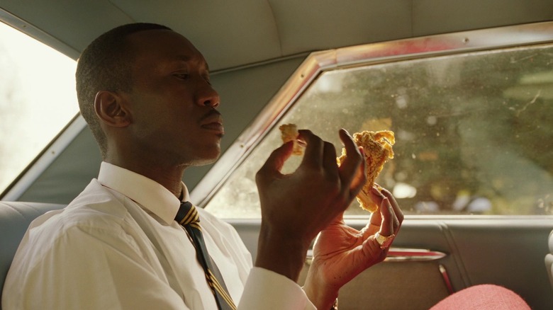 Don Shirley eating chicken in the back seat of a car in Green Book
