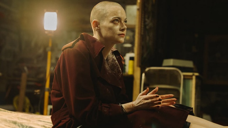 Bugonia: Emma Stone as Michelle in bathrobe, shaved head, and chained up in basement
