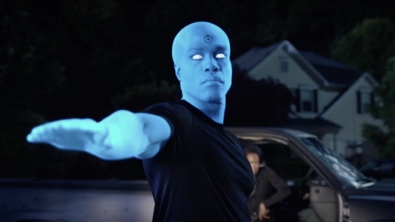 Doctor Manhattan gestures to the camera.