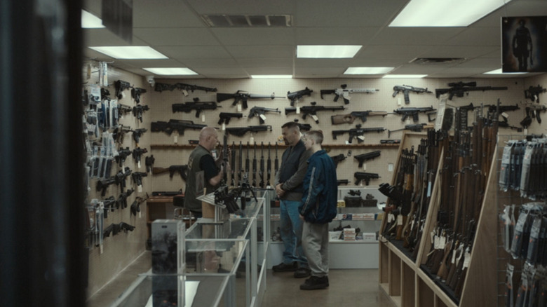 Nick Offerman's Jerry Kane stands next to his son, Jacob Tremblay's Joe Kane, as they talk to a gun shop owner in Sovereign